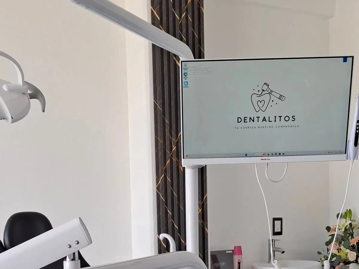 Sala de atención de Dentalitos, con unidad dental, lavabo y pantalla